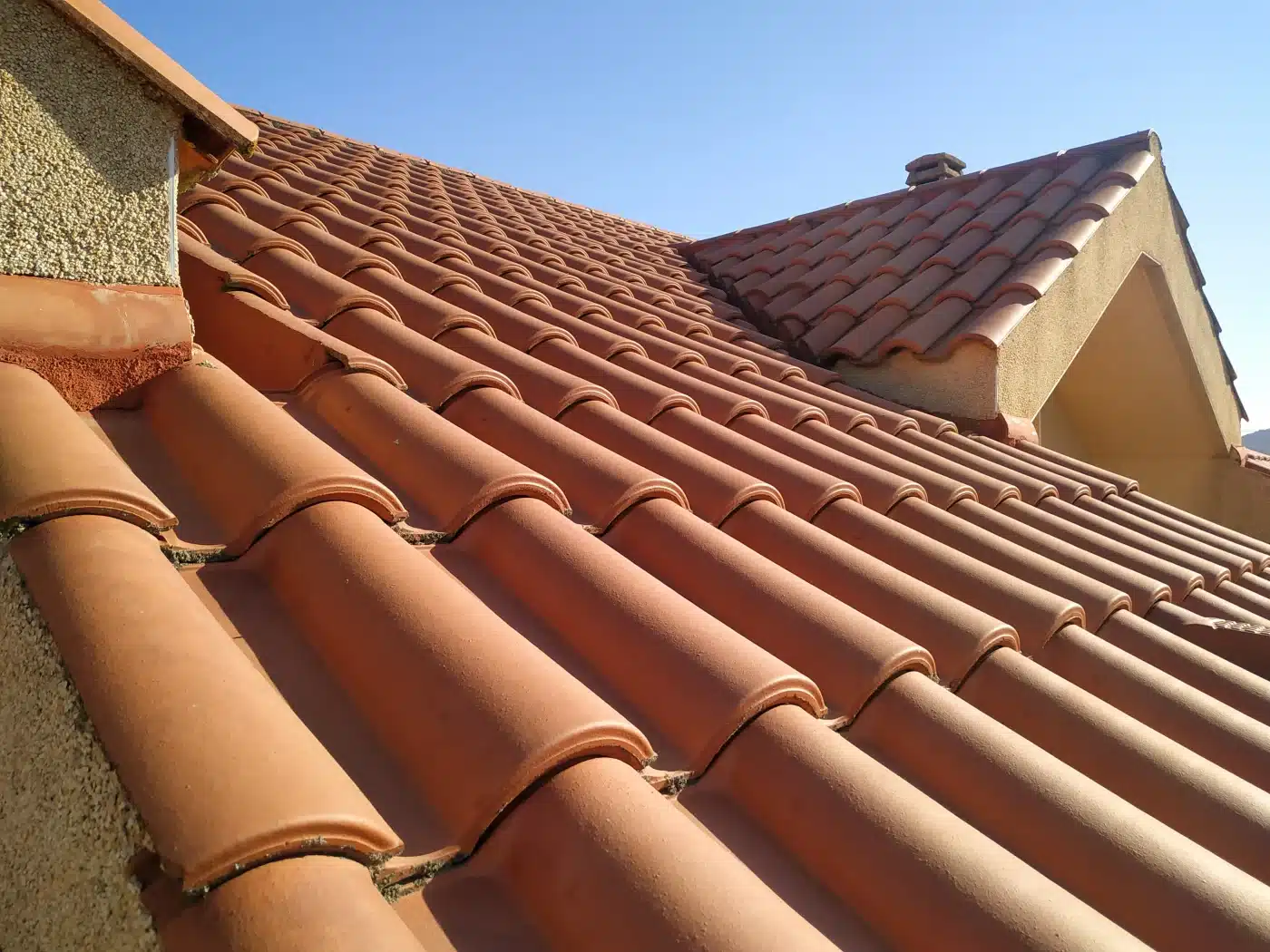 A freshly finished clay-tile roof against a clear sky